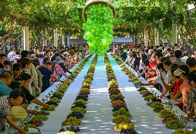 People taste grapes at a grape fair in Turpan, northwest China's Xinjiang Uygur Autonomous Region, Aug. 17, 2024. (Xinhua/Chen Shuo)