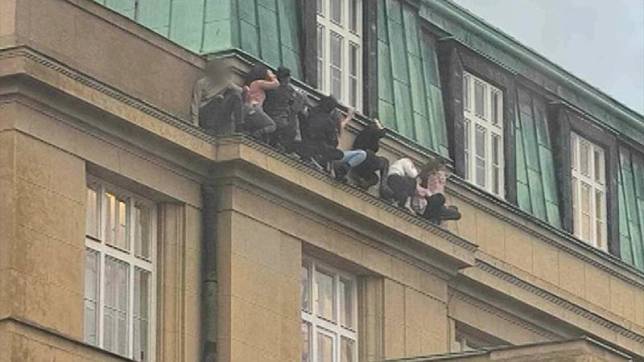位於布拉格的查理大學21日發生大規模槍擊案，民眾懸空蹲在屋頂躲子彈。（翻攝自X@iSeeRacist）