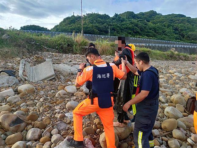 中國籍男子搭小艇闖林口後坑溪，被海巡與消防人員攙扶上岸。圖／台視新聞