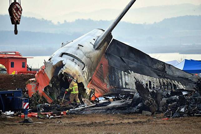 A member of the South Korean rescue team works at the site of an airplane crash at the Muan International Airport, in South Korea, on Dec. 30, 2024. (Photo by Jun Hyosang/Xinhua)