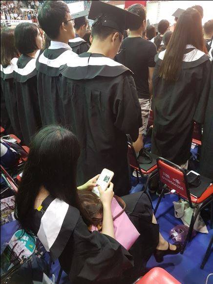今日有不少大學舉行畢業典禮，網路紅人「A濫」林雅強今早PO出一張照片說明，剛剛畢典唱國歌時，發現前面一名中國學生坐著沒起立，笑稱：「比我們的退將有意識多了！」(圖擷取自林雅強臉書)