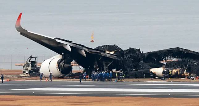 一架日本航空客機在羽田機場降落時與準備運送賑災物資的海上保安廳飛機相撞起火，機體被燒成炭黑色。（圖／美聯社／達志影像）