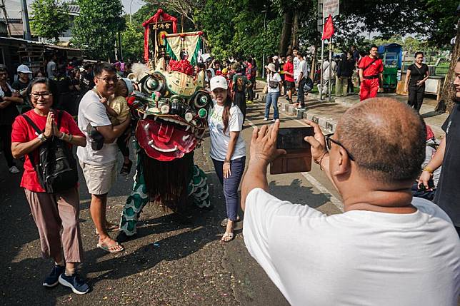 People take pictures with a lion dance performer before the Gotong Toapekong cultural celebration at Pasar Lama in Tangerang, Banten Province, Indonesia, Sept. 21, 2024. (Photo by Kurniawan Masud/Xinhua)