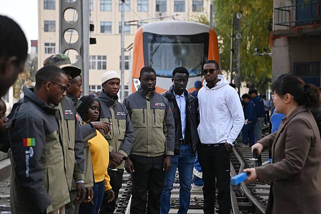 A teacher guides trainees from Guinea on how to use rail gauge measuring instrument at Tianjin Railway Technical and Vocational College in north China's Tianjin, Nov. 11, 2024. (Xinhua/Li Ran)