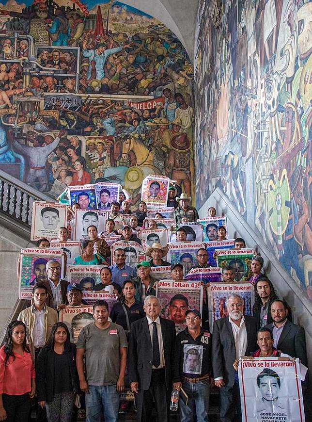 墨西哥總統羅培茲歐布拉多（前排中）日前接見5年前集體失蹤遭屠殺43名學生家長，允諾協助重新調查案情。   圖：翻攝自羅培茲歐布拉多臉書