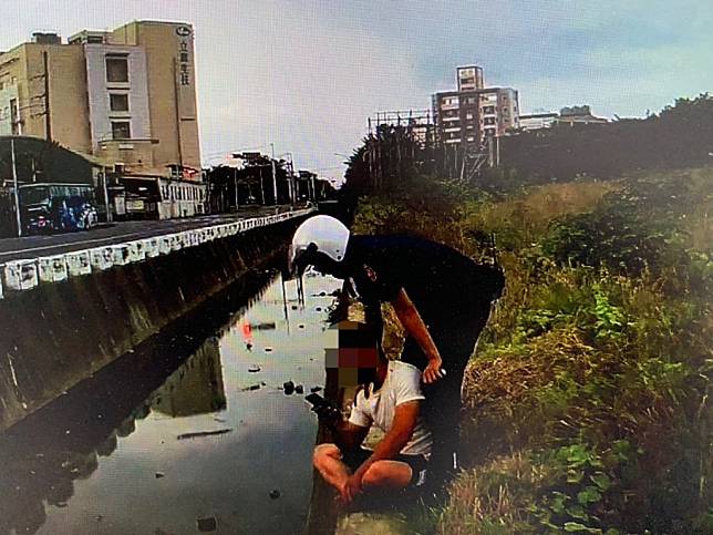 永康警方一路追著棄車逃跑的阮男至水溝旁，終於控制其行動。(讀者提供)