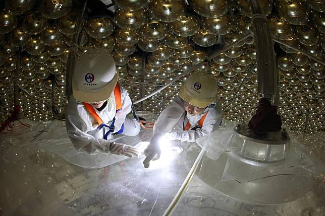 Researchers Ma Xiaoyan &reg; and Zhao Jie check the acrylic sphere of the central detector of the Jiangmen Underground Neutrino Observatory (JUNO) in Jiangmen, south China's Guangdong Province, Nov. 23, 2024. The main part of the central detector has been constructed recently. As one of the world's most powerful experiments to uncover neutrino mystery, JUNO is expected to operate for at least 30 years. (Xinhua/Jin Liwang)