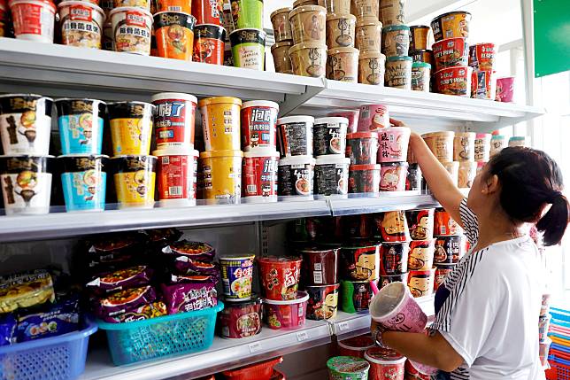 A saleslady arranges Chinese instant noodles in a Chinese grocery store in Pasay City