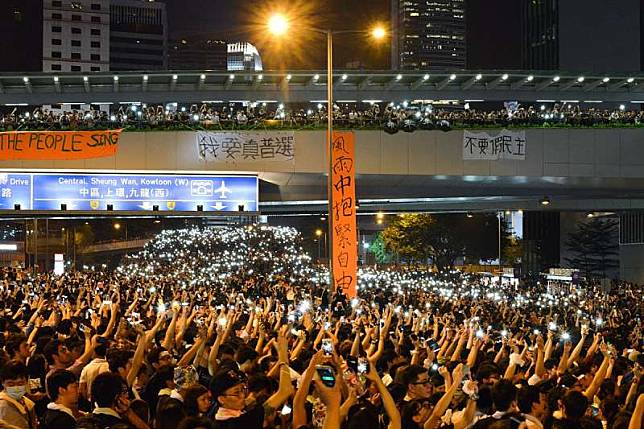 「我想起蔡總統當年這一番說話，適逢國際局勢丕變，因此冒昧懇請蔡總統，能『透過聲援及行動來支持香港人民』，共同抵擋中共逆流歷史，為港人帶來一絲希望。」圖為2014年9月29日，「雨傘運動」示威者舉起手機。（資料照，Maxlmn @ Wikipedia / CC BY 2.0）.jpg