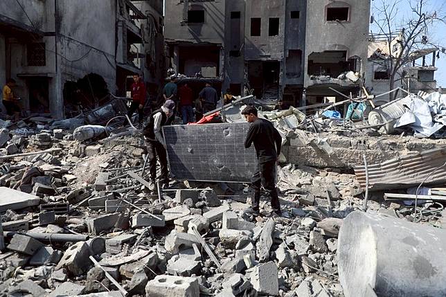 People clear debris from buildings damaged by Israeli airstrikes in the Shuja'iyya neighborhood, east of Gaza City, on March 18, 2025. The Palestinian death toll from Israeli airstrikes across the enclave early Tuesday has risen to 413, Gaza health authorities reported, adding women and children were among those killed. (Photo by Rizek Abdeljawad/Xinhua)
