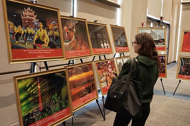 A woman looks at award-winning American photographers' photos taken during their journey across Guangdong, China, at a special exhibition at the California State University, Long Beach (CSULB), in Long Beach, California, the United States, on Feb. 20, 2025. (Photo by Zeng Hui/Xinhua)