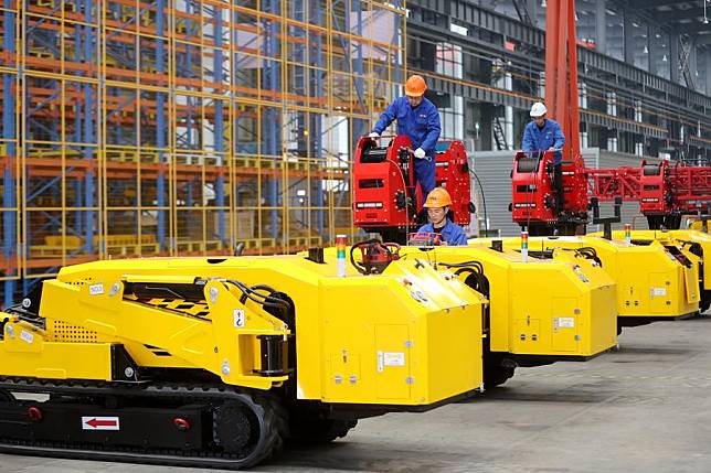 Workers assemble lightweight crawler-driven electrical tower building machines at a smart factory of Zhejiang Construction Engineering Group in Leidian Town of Deqing County, east China's Zhejiang Province, Dec. 12, 2024. (Photo by Xie Shangguo/Xinhua)