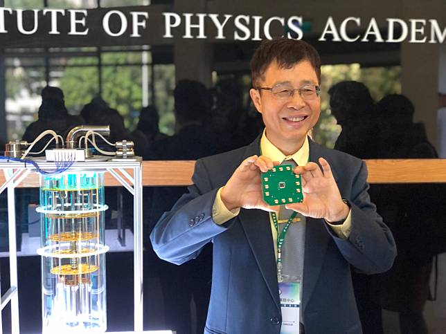 中研院物理所特聘研究員陳啟東展示中研院自研自製的5位元超導量子電腦晶片。(楊文君 攝)