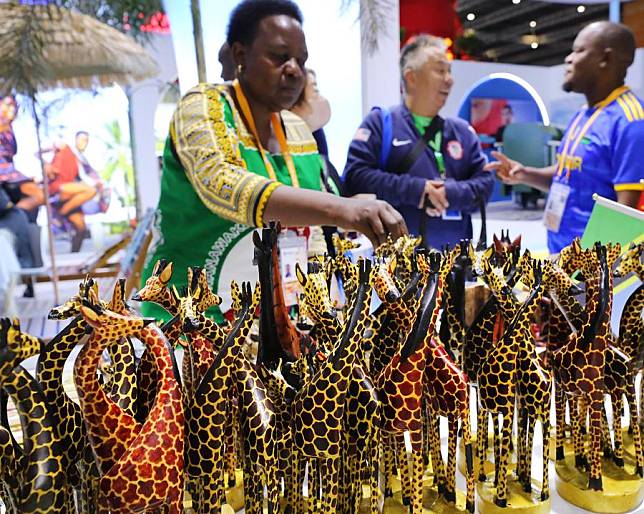 An exhibitor arranges wood carvings at the Tanzania Pavilion during the seventh China International Import Expo (CIIE) in east China's Shanghai, Nov. 7, 2024. (Xinhua/Fang Zhe)