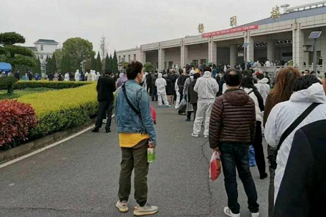 照片可見，在漢口殯儀館「靜園樓」的建築物前有大批戴着口罩的人在排隊。（網上圖片）
