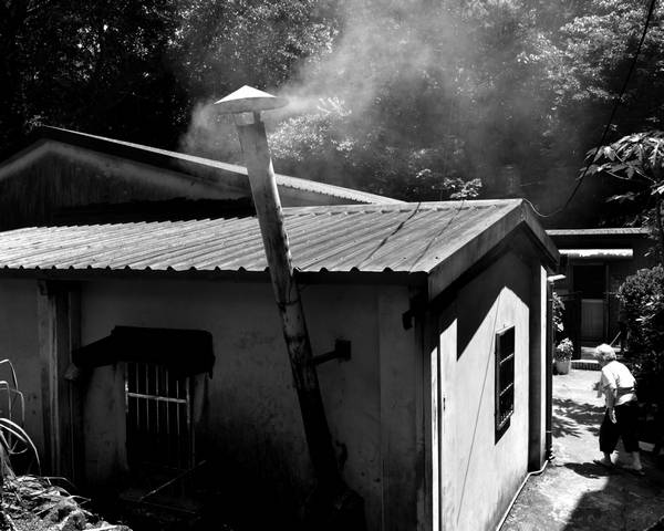 極少數還在工作的礦山煙筒管，南新山這位阿嬤在端午節前正在為兒孫們蒸煮著粽子，透過煙筒管那道煙串起祖孫情。 圖：黃金博物館提供