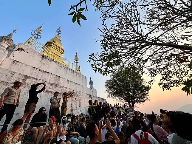 Tourists watch the sunset in Luang Prabang, Laos, Feb. 16, 2024. (Photo by Kaikeo Saiyasane/Xinhua)