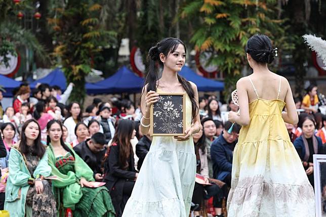 Actors display local cultural and creative products during an ethnic fashion show in Wuzhishan, south China's Hainan Province, Dec. 29, 2024. (Xinhua/Zhang Liyun)