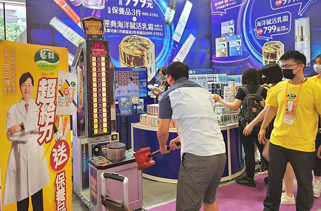 藝群攤位「大槌王遊戲機」讓消費者敲大槌得高分，領保養品當獎勵，吸引人群排隊。（藝群提供）