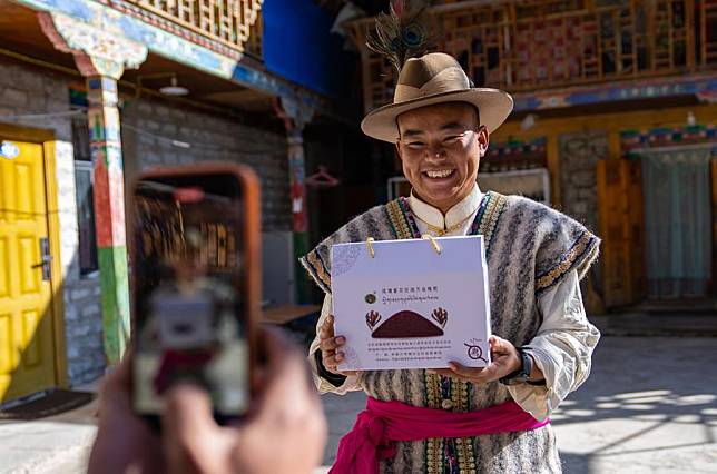 A Sherpa vlogger records a video to promote local products in Zhentang Township, Dinggye County of Xigaze, southwest China's Xizang Autonomous Region, on Dec. 13, 2024. (Xinhua/Tenzin Nyida)