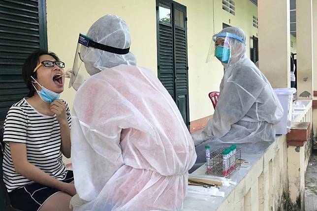 越南首都河內的衛生人員為民眾進行病毒核酸檢測。（湯森路透）