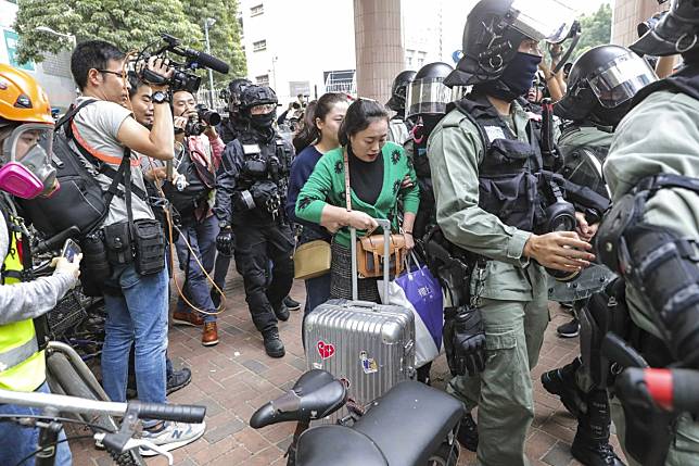 Riot police protect mainland tourists as anti-government protesters take part in a rally from North District Playground to Sheung Shui MTR Station. Photo: Edmond So