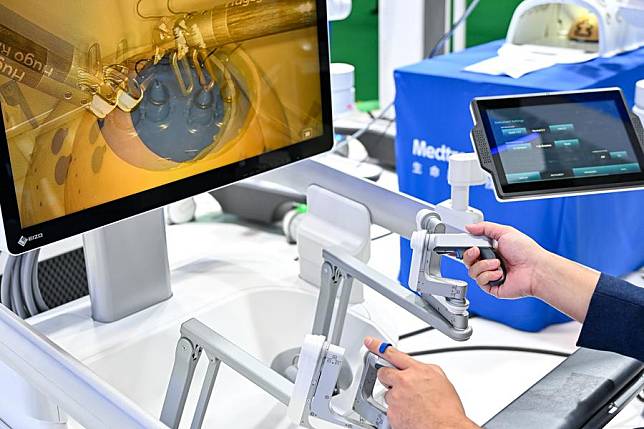 A visitor tries a surgery robot at the booth of Medtronic at the Medical Equipment &amp; Healthcare Products Exhibition Area during the 7th China International Import Expo (CIIE) in east China's Shanghai, Nov. 5, 2024. (Xinhua/Zhang Cheng)