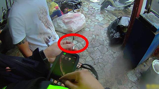 警二分局海安所警方巡邏撞見吸食K菸的吳男，當即撿起其隨手丟棄尚未熄滅菸頭，質問吳男是否是毒菸。(讀者提供)