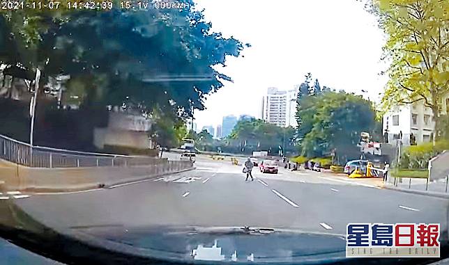 私家車駛至，光頭男跑出馬路衝向私家車。