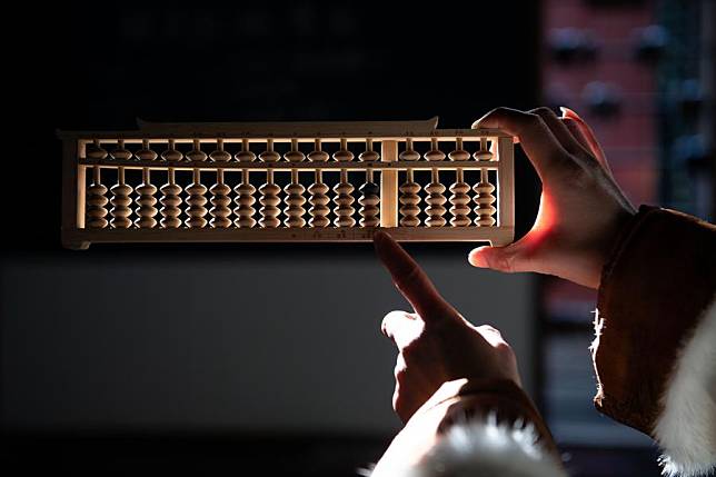 Wang Suqiu shows an abacus at Cheng Dawei Abacus Museum in Tunxi District, Huangshan, east China's Anhui Province, Jan. 9, 2025. (Xinhua/Zhang Duan)