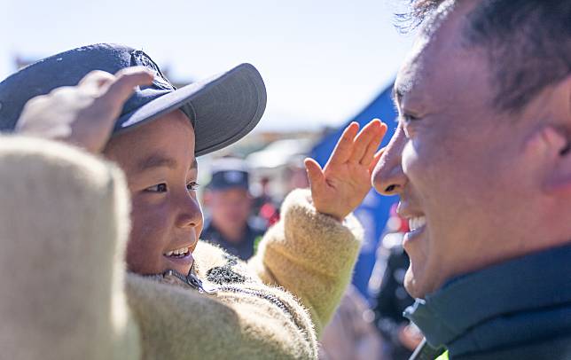 A boy wearing a police cap salutes at Gabo Village in Chamco Township, Dingri County in Xigaze, southwest China's Xizang Autonomous Region, Jan. 14, 2025. The disaster relief work in quake-hit Dingri County including makeshift houses construction, supply transportation and debris removal work have been accelerated to better meet the needs and improve the living conditions of the residents. (Xinhua/Tenzin Nyida)