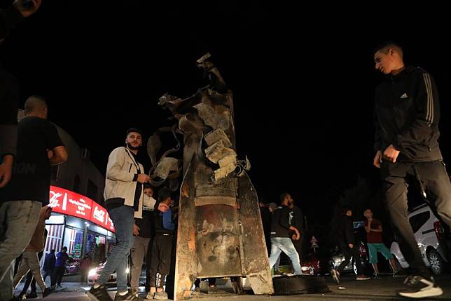 People gather around a missile at the West Bank village of Dura near Hebron, on Oct. 1, 2024. (Photo by Mamoun Wazwaz/Xinhua)