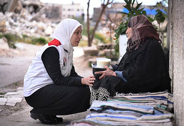 A volunteer from the team “Youth Impression of Syria” distributes a free meal to a woman on the outskirts of Damascus, Syria, on March 22, 2024. (Photo by Ammar Safarjalani/Xinhua)