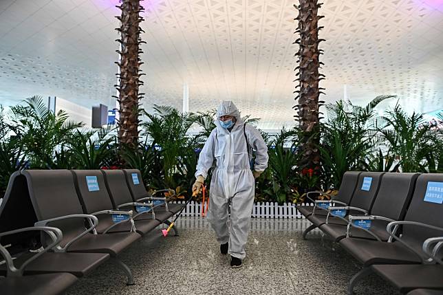 A worker in protective gear sprays disinfectant at Tianhe airport in Wuhan, after the authorities lifted the lockdown on the city on April 8 and outbound travel resumed. Photo: AFP
