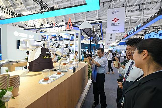 Visitors try coffee made by a robot at the 2024 World Intelligence Expo held in Tianjin Municipality, north China, June 20, 2024. (Xinhua/Sun Fanyue)