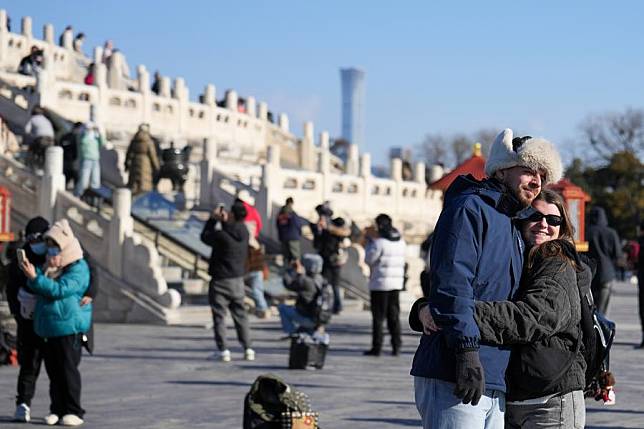 Foreign tourists pose for photos at Tiantan (Temple of Heaven) Park in Beijing, capital of China, Dec. 5, 2024. (Xinhua/Ju Huanzong)