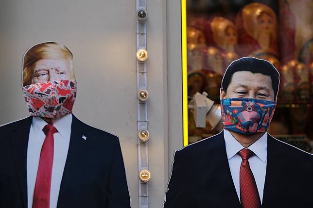 Cut-outs of US leader Donald Trump, and Chinese president Xi Jinping in masks outside a gift shop in Moscow, Russia. Photo: Reuters