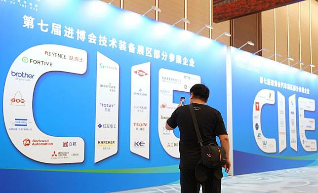 An attendee takes photos of a billboard during a pre-expo supply-demand matchmaking meeting for the Intelligent Industry &amp; Information Technology Exhibition Area and Automobile Exhibition Area of the 7th China International Import Expo (CIIE) at the National Exhibition and Convention Center (Shanghai) in east China's Shanghai, Aug. 8, 2024. (Photo by Chen Haoming/Xinhua)