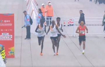 非洲跑者（白衣者）疑伸出手示意要與中國籍跑者何杰（紅衣者）齊步。（翻攝李老師不是你老師X）
