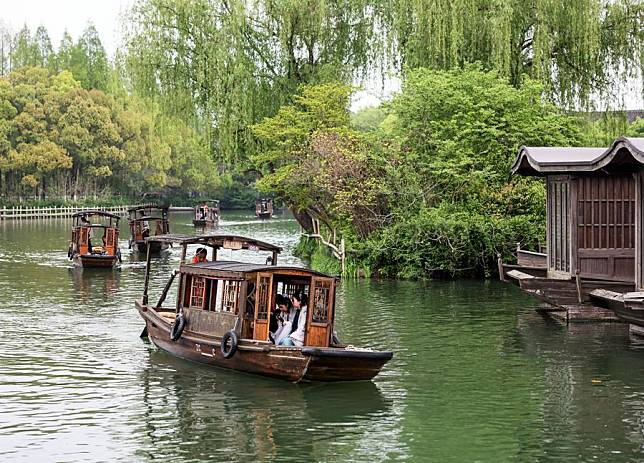 Tourists visit the water town Wuzhen on rowing boats in Jiaxing City, east China's Zhejiang Province, April 11, 2024. (Xinhua/Lan Hongguang)