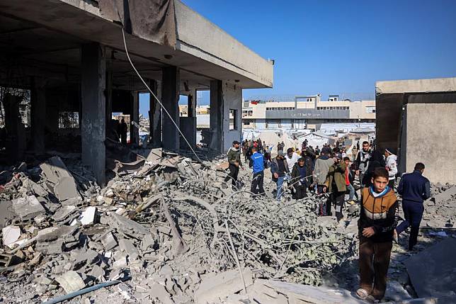 People gather at a building destroyed in an Israeli bombing in the center of the southern Gaza Strip city of Khan Younis, on Jan. 2, 2025. (Photo by Rizek Abdeljawad/Xinhua)