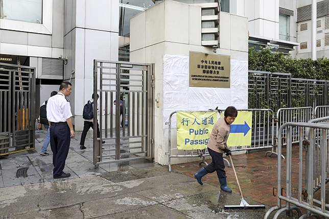 A worker continues to clean-up the mess left by protestors outside the liaison office in Sai Ying Pun. Photo: Nora Tam