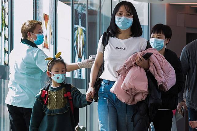 A health officer screens arriving passengers from China at Changi International airport in Singapore, where a fifth coronavirus case has been confirmed. Photo: AFP