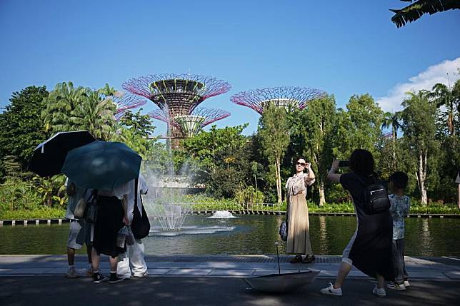 Tourists take photos at Singapore's Gardens by the Bay on Oct. 3, 2024. (Photo by Then Chih Wey/Xinhua)