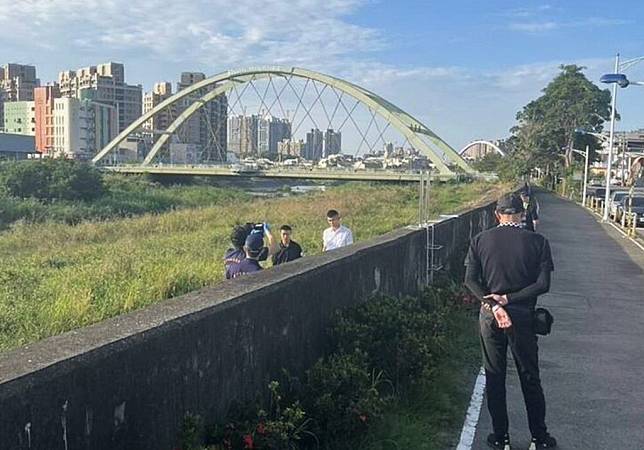 台中市昨日下午民眾驚見東區旱溪旁有一具男性屍體，頭套塑膠袋，警方到場勘驗調查。（記者陳金龍翻攝）