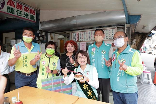 黃秀芳在奠安宮前大啖在地料理「阿美姊高麗菜飯」。（圖／黃秀芳競選辦公室提供）