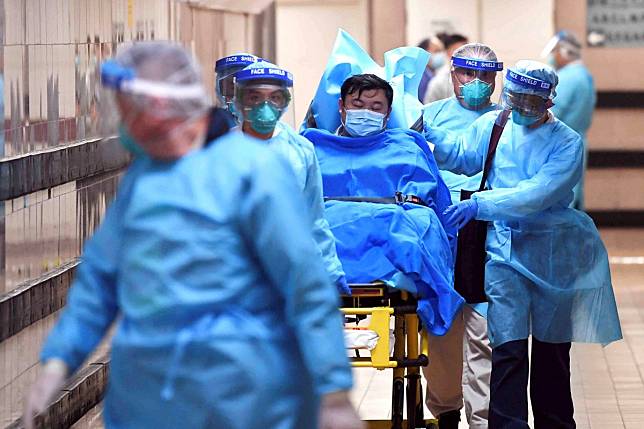 Medical staff transfer a patient suspected as a Covid-19 case at Queen Elizabeth Hospital in Hong Kong. Photo: Reuters