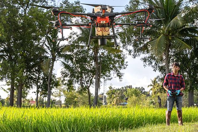 A Thai farmer operates a DJI agricultural drone in Roi Et, Thailand, on Aug. 1, 2022. (Xinhua/Wang Teng)