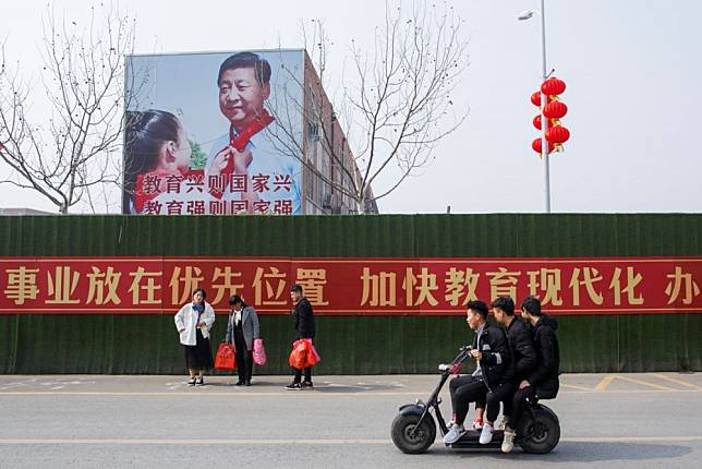學生經過中國宣傳看板前。（湯森路透）