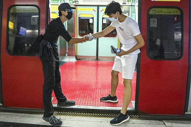 Anti-government protesters obstruct train doors to stop MTR services at Hung Hom station during the citywide strike on August 5. Photo: Felix Wong